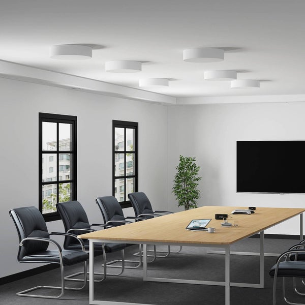 Moderner Konferenzraum mit runden weißen Deckenleuchten, großem Holztisch und dunklen Bürostühlen.