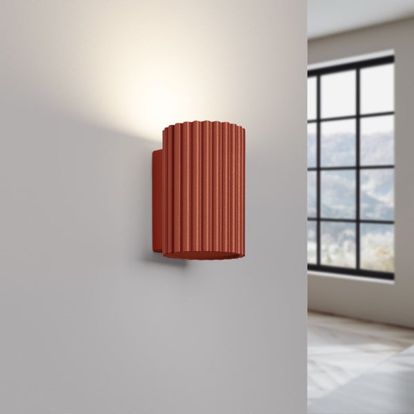 Wandleuchte mit gerippter Oberfläche an einer Wand