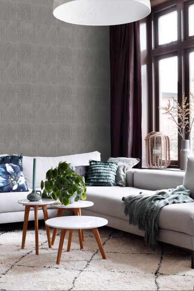 Wohnzimmer mit grauer Tapete, Sofa und Beistelltischen.