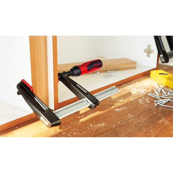 Werkbank mit Schraubzwinge, Schrauben, Wasserwaage und Holzbrett