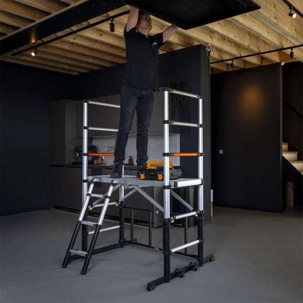 Person auf einer Arbeitsplattform aus Aluminium bei Arbeiten an einer Decke mit Holzbalken in einem modernen, organisierten Innenraum.