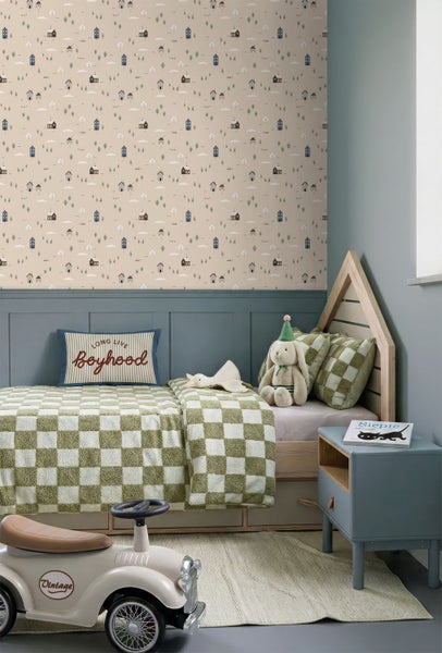 Kindertapete mit Häusern und Bäumen in einem hellen Kinderzimmer mit Schreibtisch und Dekoration.