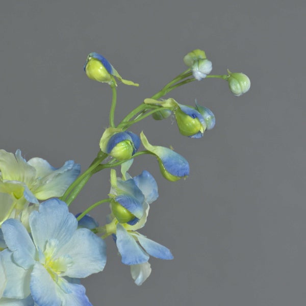Künstlicher Rittersporn-Zweig mit hellblauen Blüten und grünen Knospen.