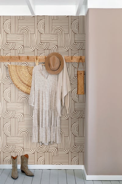 Gemusterte Tapete in einem Flur mit Holzgarderobe, Kleid, Hut und Stiefeln