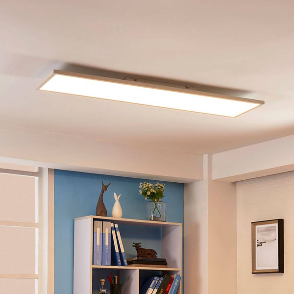 Flaches, rechteckiges LED-Panel an der Decke in einem hellen Büro mit einem Bücherregal und Dekorationselementen.