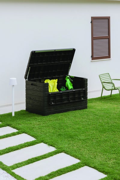 Geöffnete, schwarze Gartenbox mit Gartenwerkzeug auf Rasen