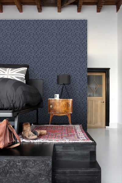 Schlafzimmer mit Bett, Nachttisch, Teppich und gemusterter Tapete