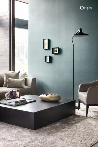 Wohnzimmer mit Sofa, Sessel, Tisch, Stehlampe und Dekoration