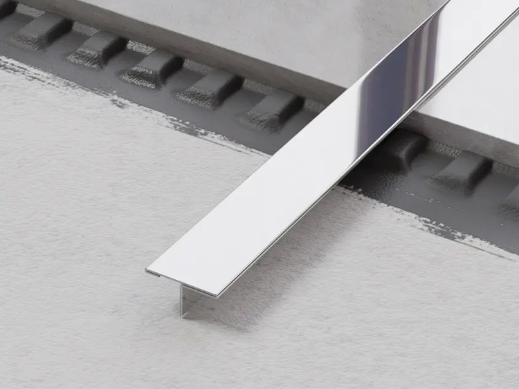 Detailansicht einer Edelstahlschiene auf einem Bodenbelag.