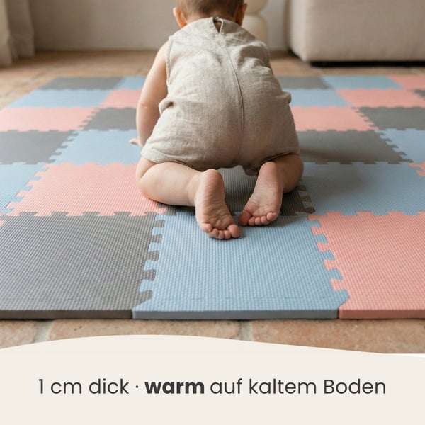 Baby krabbelt auf einer 1 Zentimeter dicken Puzzlematte aus Schaumstoff.