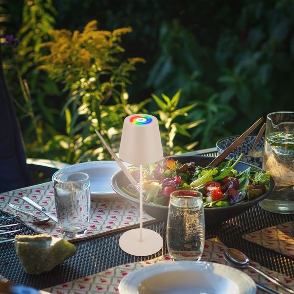 Moderne LED-Tischleuchte für den Außenbereich auf einem gedeckten Esstisch mit Salat und Getränken im Garten.