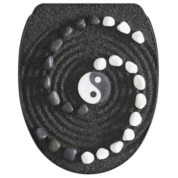 WC-Sitz mit Yin-Yang-Symbol und Zen-Steinen in einer Spirale auf dunklem Sanddekor.