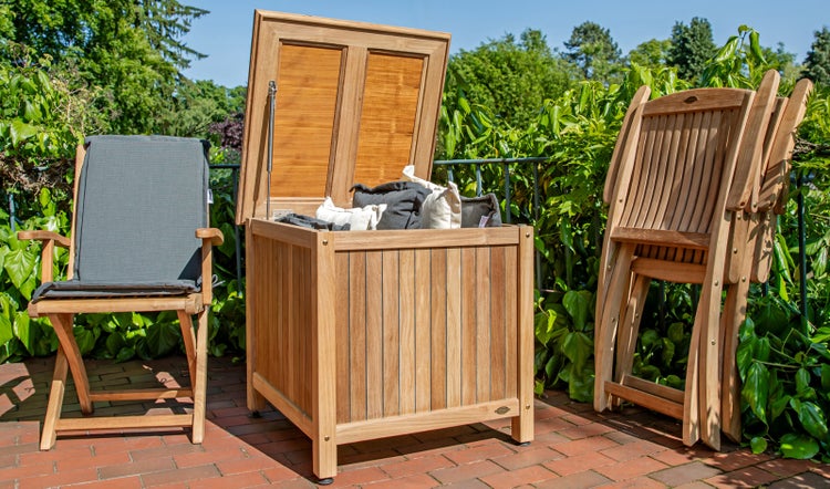Szene mit Holzgartenmöbeln und einer Aufbewahrungsbox mit geöffnetem Deckel