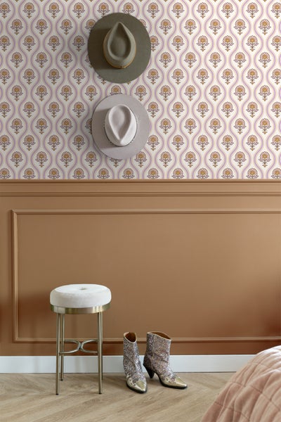 Dekorative Tapete mit floralem Muster in einem stilvollen Raum mit Hocker, Stiefeln und Hüten.