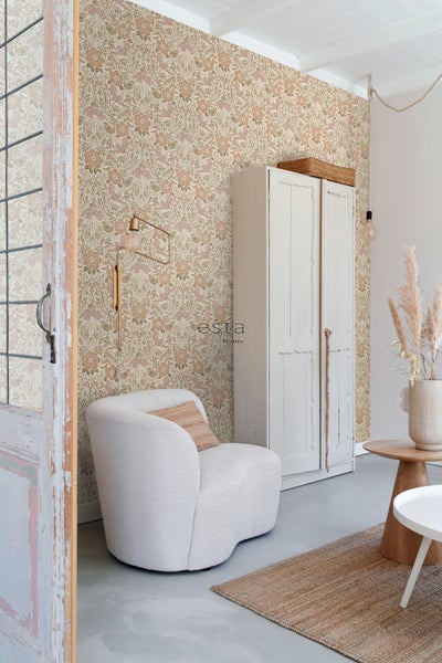 Wohnzimmer mit blumiger Tapete, Sessel, Schrank und Teppich