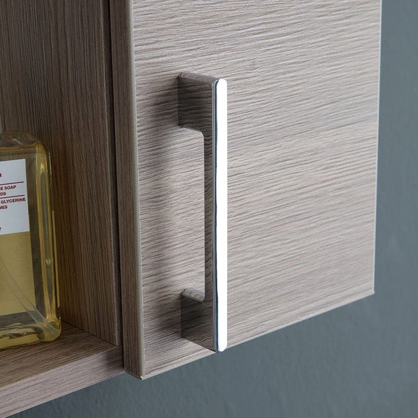 Detailaufnahme eines Badezimmerschranks in Holzoptik mit einem verchromten Metallgriff.