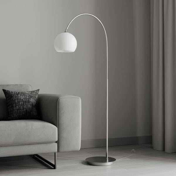Stehlampe mit gebogenem, verchromtem Gestell und kugelförmigem Lampenschirm neben einem Sofa