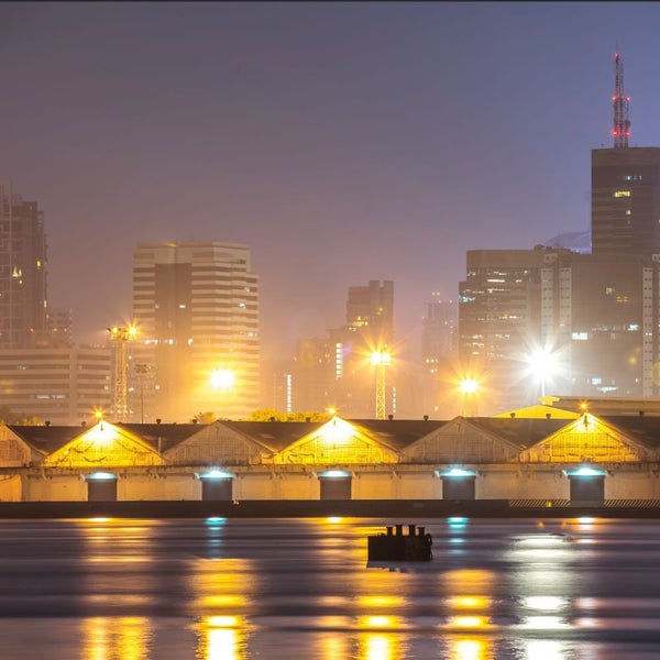 Skyline mit Gebäuden und Hafen bei Nacht