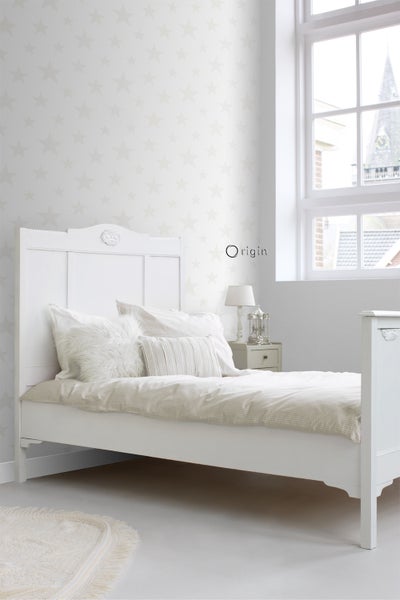 Helles Schlafzimmer mit Bett, Nachttisch, Lampe und Sternentapete