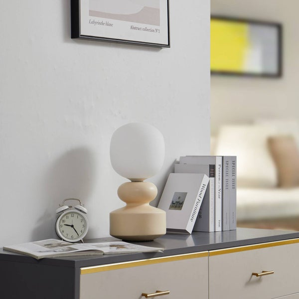 Dekorative Szene mit Tischleuchte, Büchern und Wecker auf einer Kommode