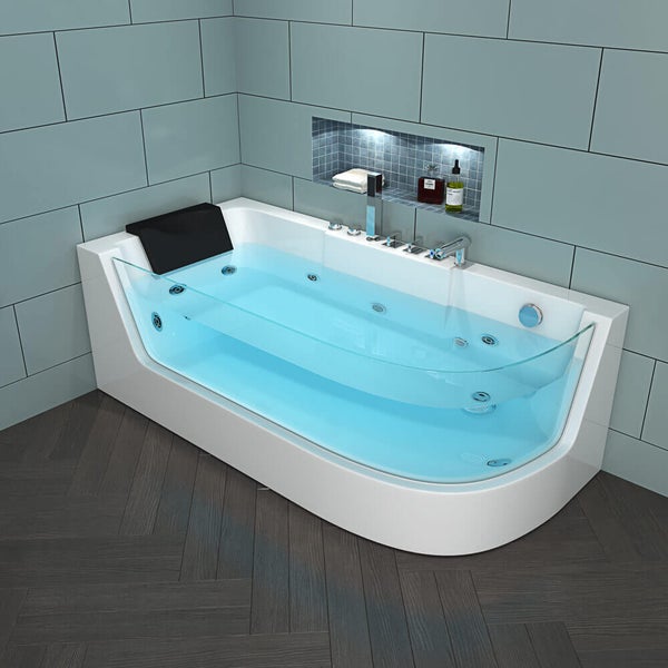 Moderne Whirlpool Badewanne mit Glaseinsatz und Kopfstütze in einem gefliesten Badezimmer mit Wandnische.