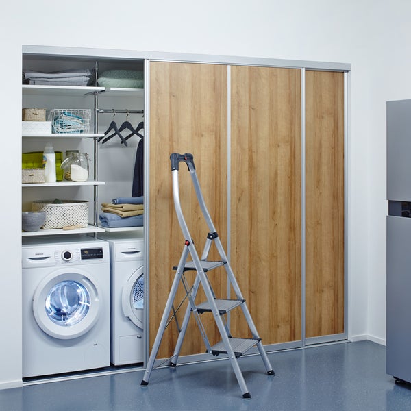 Waschküche mit Waschmaschine, Trockner, Regalen, Schiebetürenschrank und Trittleiter