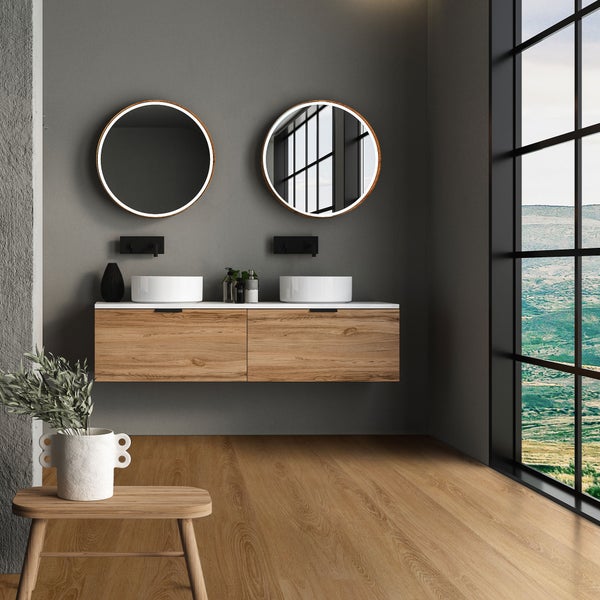 Modernes Badezimmer mit Doppelwaschtisch aus Holz, zwei Aufsatzwaschbecken, runden beleuchteten Spiegeln und großem Fenster mit Landschaftsblick.