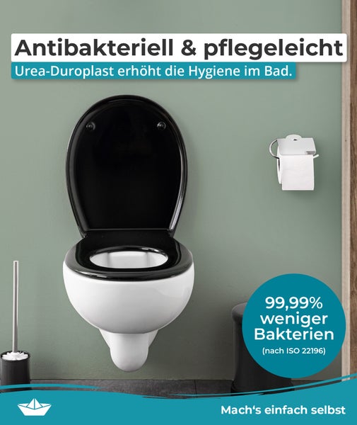 Wandhänge WC mit antibakteriellem WC Sitz aus Urea Duroplast an einer Wand mit WC Papierhalter und WC Bürste montiert.
