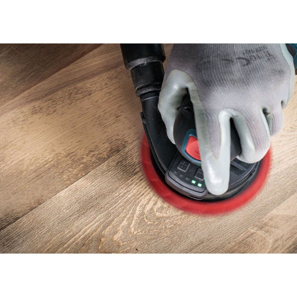 Rotationsschleifer in Benutzung auf Holzoberfläche mit Hand und Schutzhandschuh