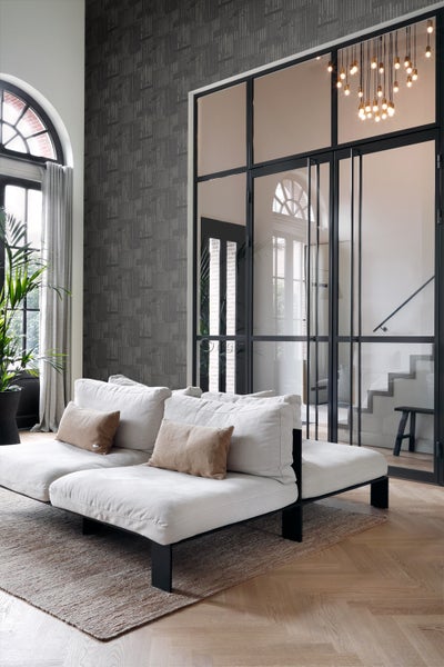 Helles Wohnzimmer mit Sofa, Teppich und dekorativer Glastür