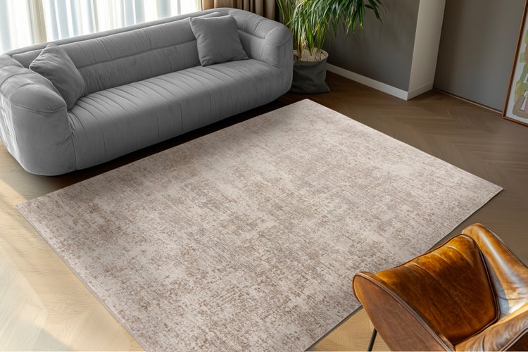 Wohnzimmer mit modernem Sofa und beigem Vintage Teppich auf Parkettboden.