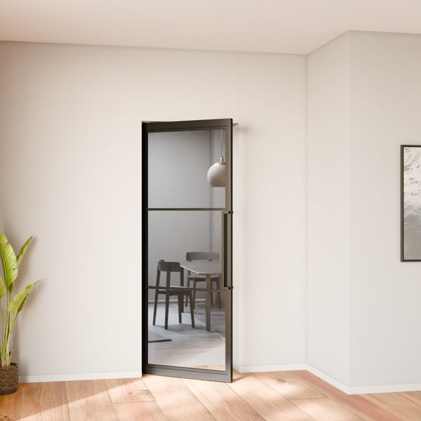 Glastür mit Metallrahmen im Industriedesign in einem hellen Raum mit Holzfußboden und Blick auf eine Essgruppe.