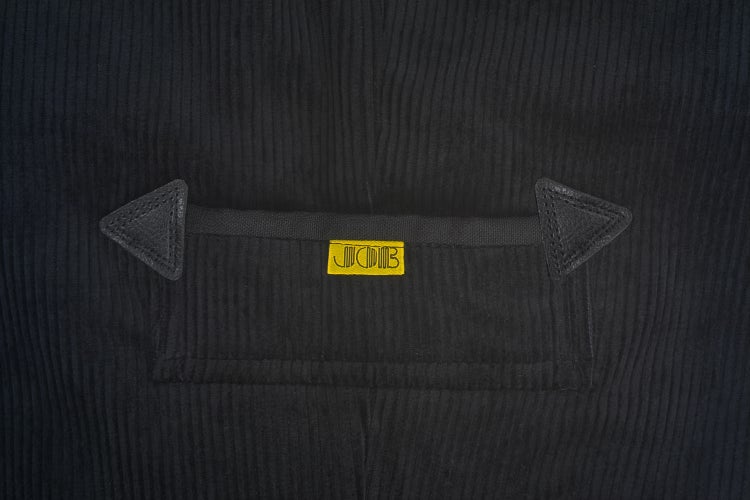 Nahaufnahme einer schwarzen Tasche aus Cord mit dreieckigen Verstärkungen und JOB Logo.