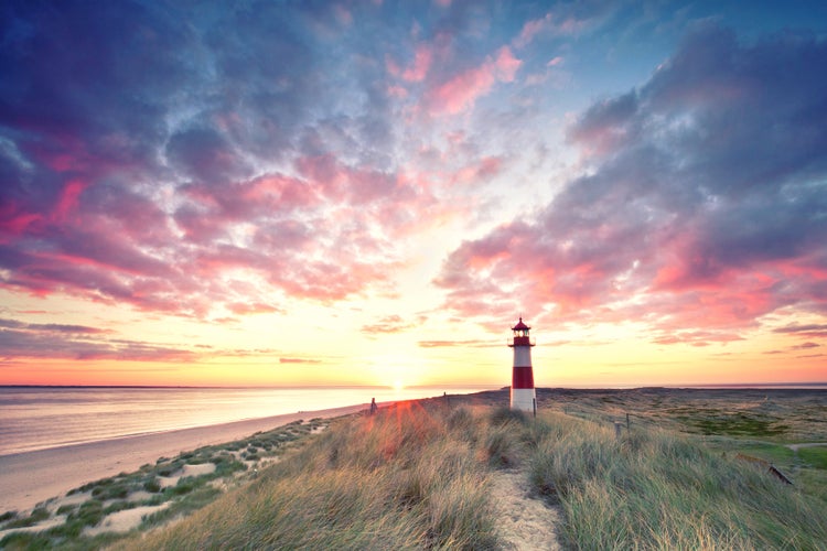 Landschaft mit Strand, Düne und Leuchtturm bei Sonnenuntergang