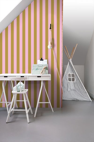 Vertikal gestreifte Tapete in einem hellen Kinderzimmer mit weißem Schreibtisch, Stuhl und einem Spielzelt unter einer Dachschräge.
