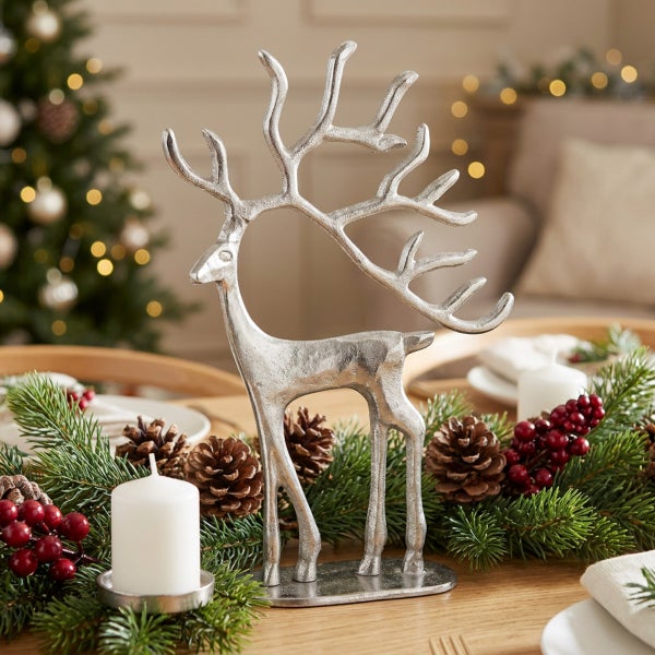 Dekorative Rentierfigur aus Metall als Tischdekoration für die Weihnachtszeit in festlicher Umgebung.