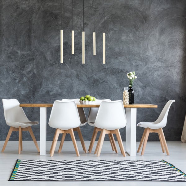 Modernes Esszimmer mit Holztisch, weißen Stühlen, geometrischem Teppich und fünf hängenden Leuchten vor einer dunklen strukturierten Wand