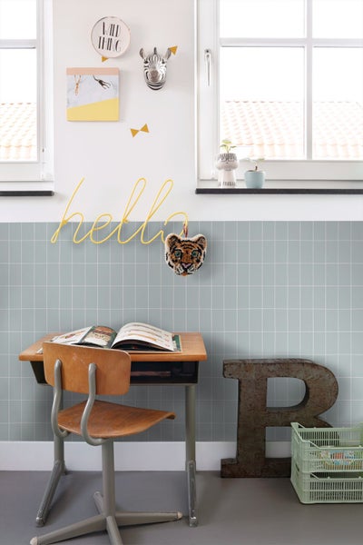Helles Kinderzimmer mit Schreibtisch, Stuhl und dekorativen Elementen