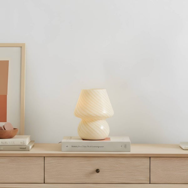 Tischleuchte in Pilzform auf einem Holztisch mit Schubladen