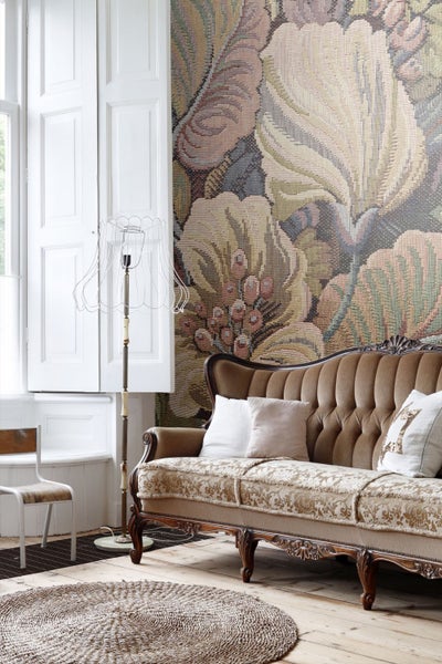 Fototapete mit großem floralem Wandteppich-Muster im Wohnzimmer mit klassischem Sofa.