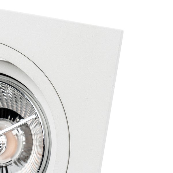 Detailansicht eines quadratischen Einbaustrahlers in Weiß mit rundem Innenring und Reflektorlampe.
