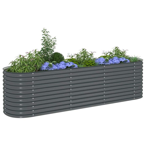 Ovales Hochbeet aus verzinktem Stahl mit Wellenprofil in Anthrazit, bepflanzt mit verschiedenen Grünpflanzen und blauen Blumen.