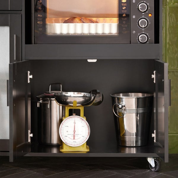 Küchenszene mit Ofen, Küchenwaage, Kochtopf und Eiseimer in einem Küchenschrank