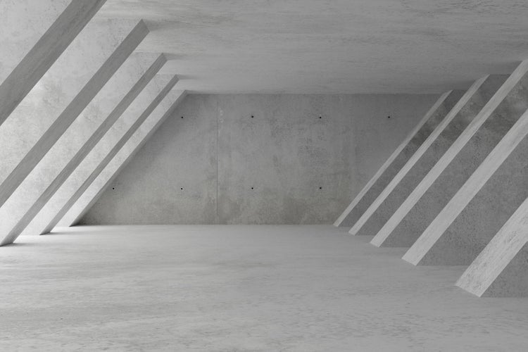 Leerer, moderner Raum mit Sichtbetonwänden und schrägen Betonstützen, minimalistisches Architekturdesign.