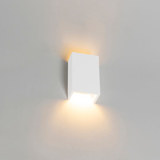 Weiße, würfelförmige Wandleuchte strahlt Licht nach oben und unten