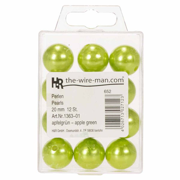 Ostergesteck mit weißen und gelben Tulpen, Wachteleiern und Moos in einer runden Schale auf einem Holztisch mit dekorativen Perlen.