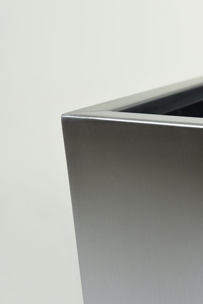 Detailaufnahme der Ecke eines Pflanzgefäßes aus gebürstetem Edelstahl.