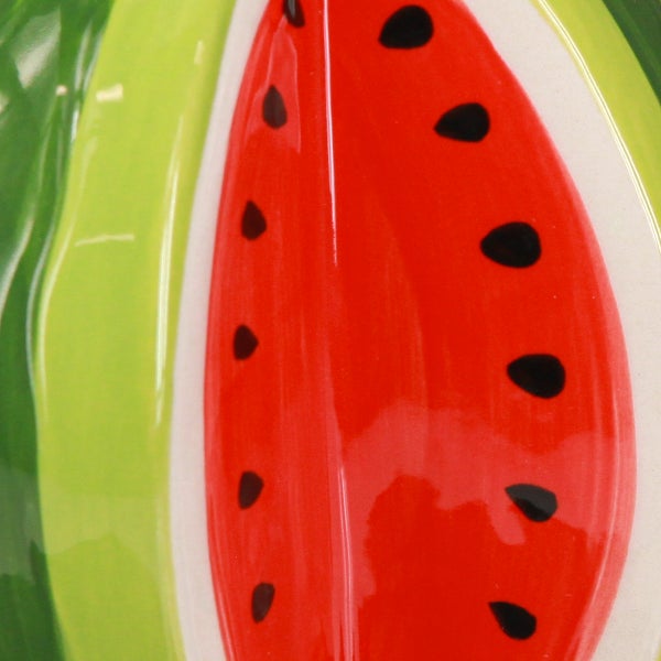 Glasierte Keramikoberfläche mit einem rot-grünen Wassermelonen-Muster und schwarzen Kernen.