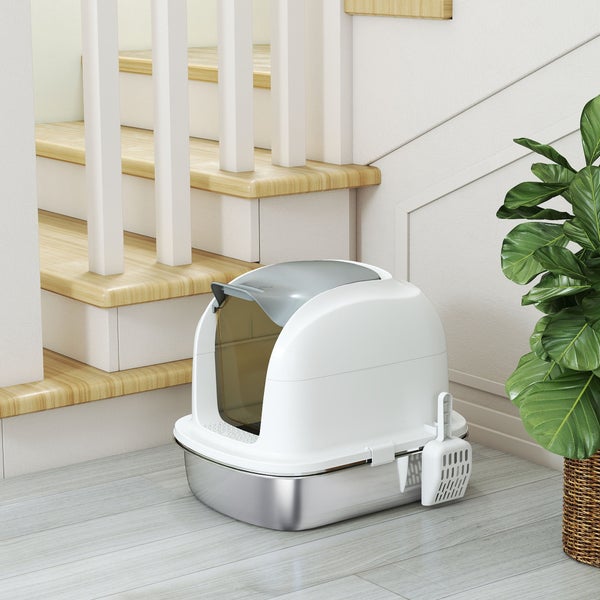 Moderne Katzentoilette mit Haube, Edelstahlschüssel und weißem Aufsatz neben einer Treppe und einer Zimmerpflanze.