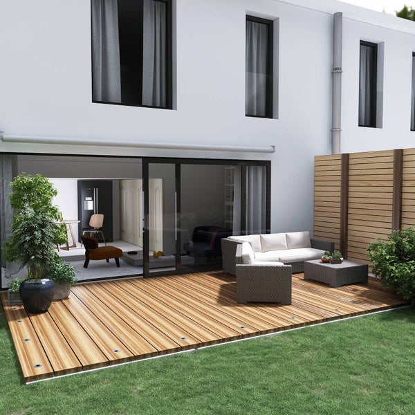 Moderne Terrasse mit Holzdeck, Lounge-Set aus Geflecht mit Sofa, Sessel und Tisch sowie Sichtschutzzaun aus Holz an einer Glasfront.